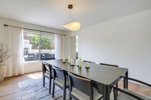 Ein Essbereich mit Tisch, Stühlen, Kerzen und Blick ins Freie.
