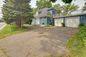 A residential house with a driveway, garage, and a large tree. - Shared Deck w/ Lake Views! St Joseph Upstairs Apt (St Joseph)