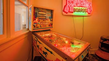 Een flipperspel met een neonreclame erboven.
