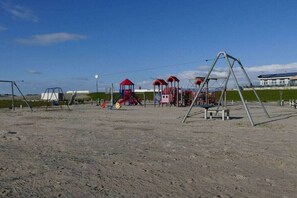 Un parque infantil con columpios y estructuras para escalar.