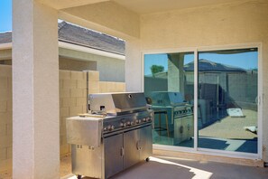 An outdoor patio with a stainless steel grill and a glass door leading to a backyard. - Yard, Patio & Spacious Interior! Casa Grande Home (Casa Grande)
