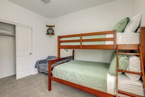 A bunk bed with a wooden frame and a green quilt, a white door, and a wall clock. - Yard, Patio & Spacious Interior! Casa Grande Home (Casa Grande)