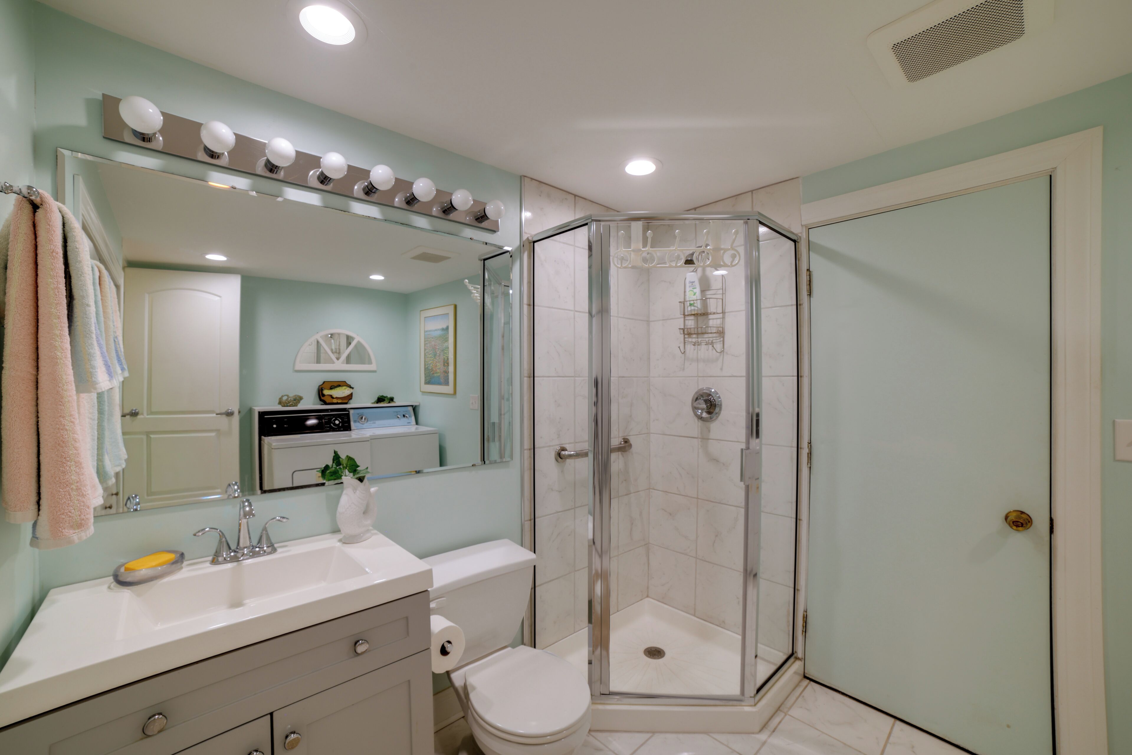 A bathroom with a shower, sink, and toilet.