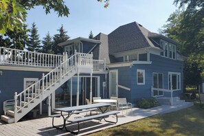 A two-story house with a covered patio, a staircase, and a dining area. - Lakefront Apt w/ Sweeping Views in St Joseph (St Joseph)