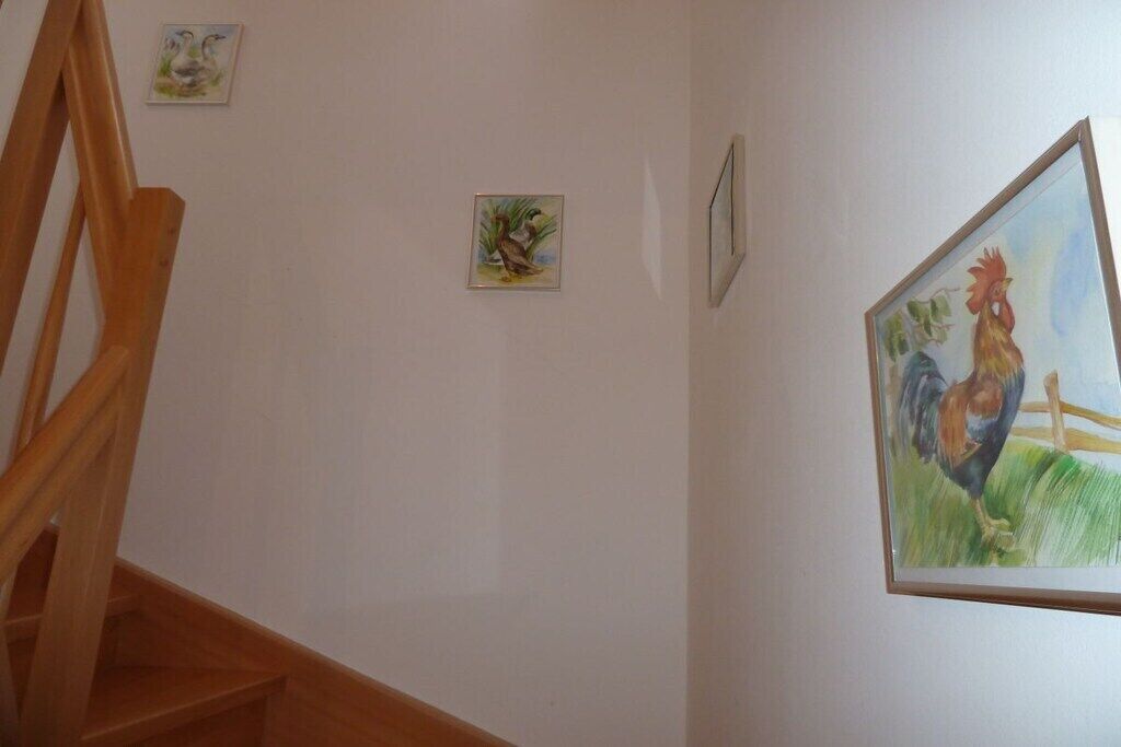 Una escalera con barandillas de madera y una pared decorada con cuadros.