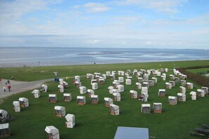 Un vaste champ découvert où se trouvent de nombreuses petites structures rectangulaires blanches, peut-être des logements temporaires, disposées en rangées.