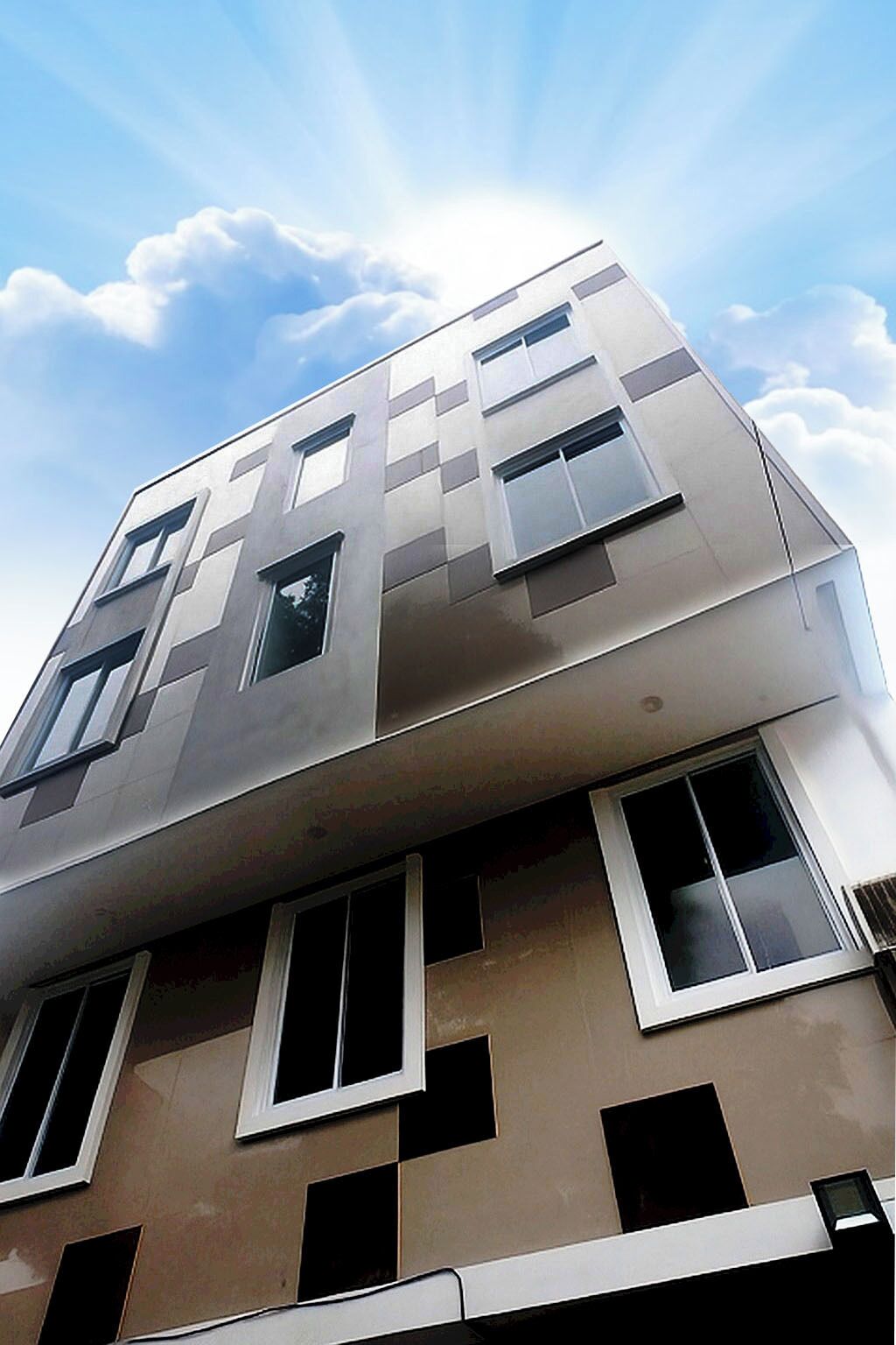 A multi-story building with a modern architectural design, featuring a series of windows and a flat roof.