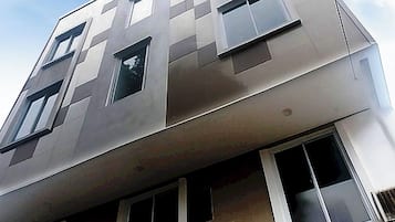 A multi-story building with a modern architectural design, featuring a series of windows and a flat roof.