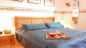 A hotel room with a bed, bedside table, lamp, and a tray with breakfast items. - Holiday apartment with 1 bedroom (Kappeln Stadt)