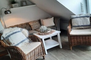 Une pièce chaleureuse avec un canapé, deux fauteuils, une petite table et un vase décoratif.