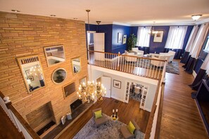 Un espace de vie à plusieurs niveaux comprenant une cheminée, un coin salon et un escalier.