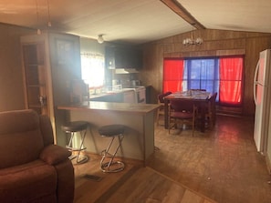 Un espacio habitable compacto con cocina, comedor y zona de estar.