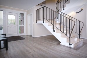 Ein modernes Interieur mit einer Wendeltreppe, Holzböden und einem Essbereich.