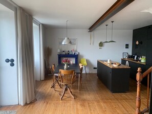 Une cuisine moderne avec un îlot central, une table à manger en bois et des chaises.