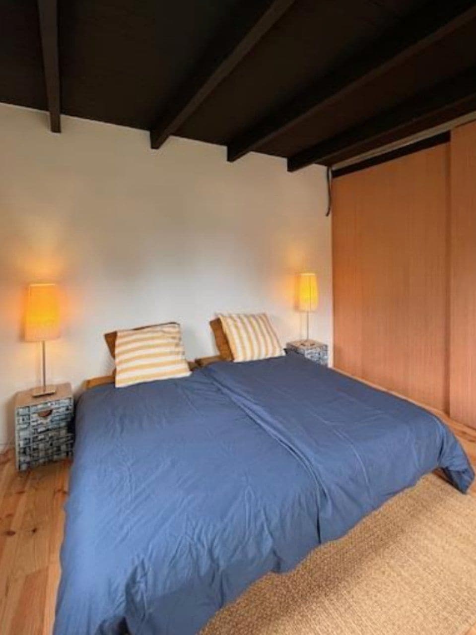 Una camera da letto con un letto, due abat-jour e una testiera in legno.