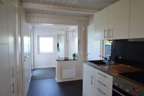 A modern kitchen with white cabinetry, a black countertop, and a built-in oven. - Holiday home with 3 bedrooms (Wesselburenerkoog)