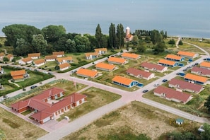 Oversigtsbillede af et kystnære boligområde med flere huse, veje og et fyrtårn.