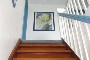Een houten trap met een witte balustrade en een lijstwerk met een bloem erop.