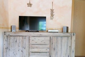 A flat-screen TV on a wooden cabinet with two speakers on either side. - Holiday apartment with 2 bedrooms (Ochtersum)