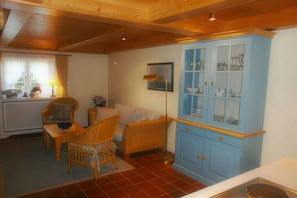 A room with a dining area, a blue cabinet with glass doors, and a radiator. - Old Beach Warden's Office No. 2 (List auf Sylt)