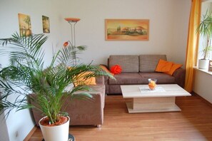 Un saló amb un sofà, una taula de centre i una planta en test.