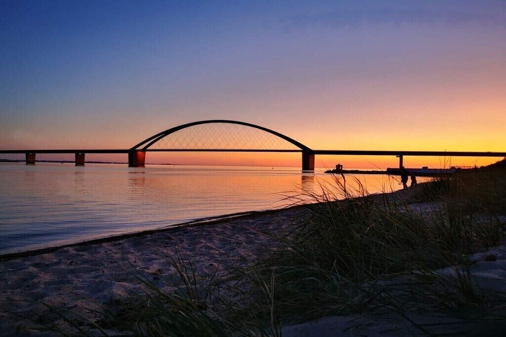 A bridge over a body of water during sunset.