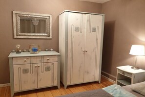 A bedroom with a bed, a nightstand, a dresser, and a wardrobe. - Holiday apartment with 1 bedroom (Niendorf  a.Fehmarn)