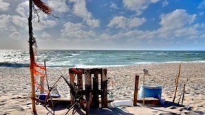 A beach with a wooden structure, a blue bucket, and a chair. - Country House Diedrichsen No. 3 (List auf Sylt)