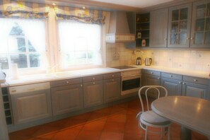 A kitchen with a window, cabinets, a sink, and a chair. - Holiday apartment with 2 bedrooms (List auf Sylt)