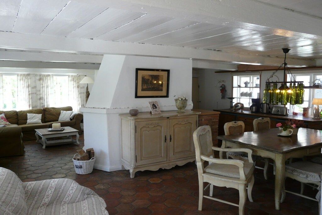 A living room with a sofa, coffee table, and a dining area with chairs and a table.