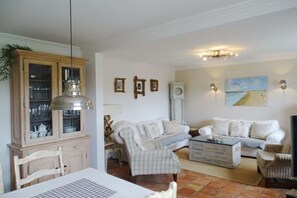 A living room with a dining table, two sofas, a cabinet, and a coffee table. - Holiday home in List with sauna and Wi-Fi (List)