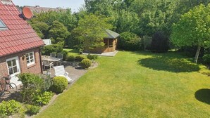 A residential property with a brick house, a small wooden structure, and a well-maintained lawn. - Holiday apartment in List with swimming pool (List)