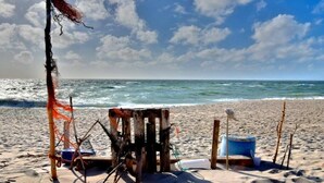 A beach with a wooden structure, a blue bucket, and a rope. - Holiday apartment in List with swimming pool (List)