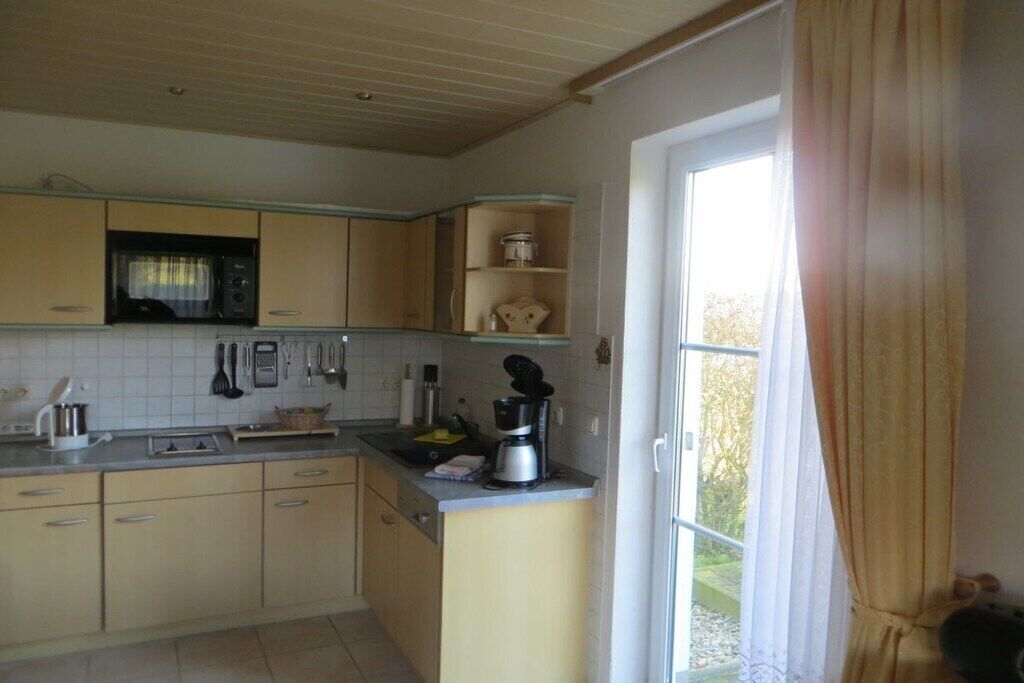 A kitchen with wooden cabinets, a microwave, and a coffee maker.