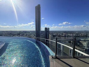 A rooftop pool with a cityscape view, including high-rise buildings and a clear sky. - Metropolitan Luxe | Balcony with Skyline Views (Brisbane City)