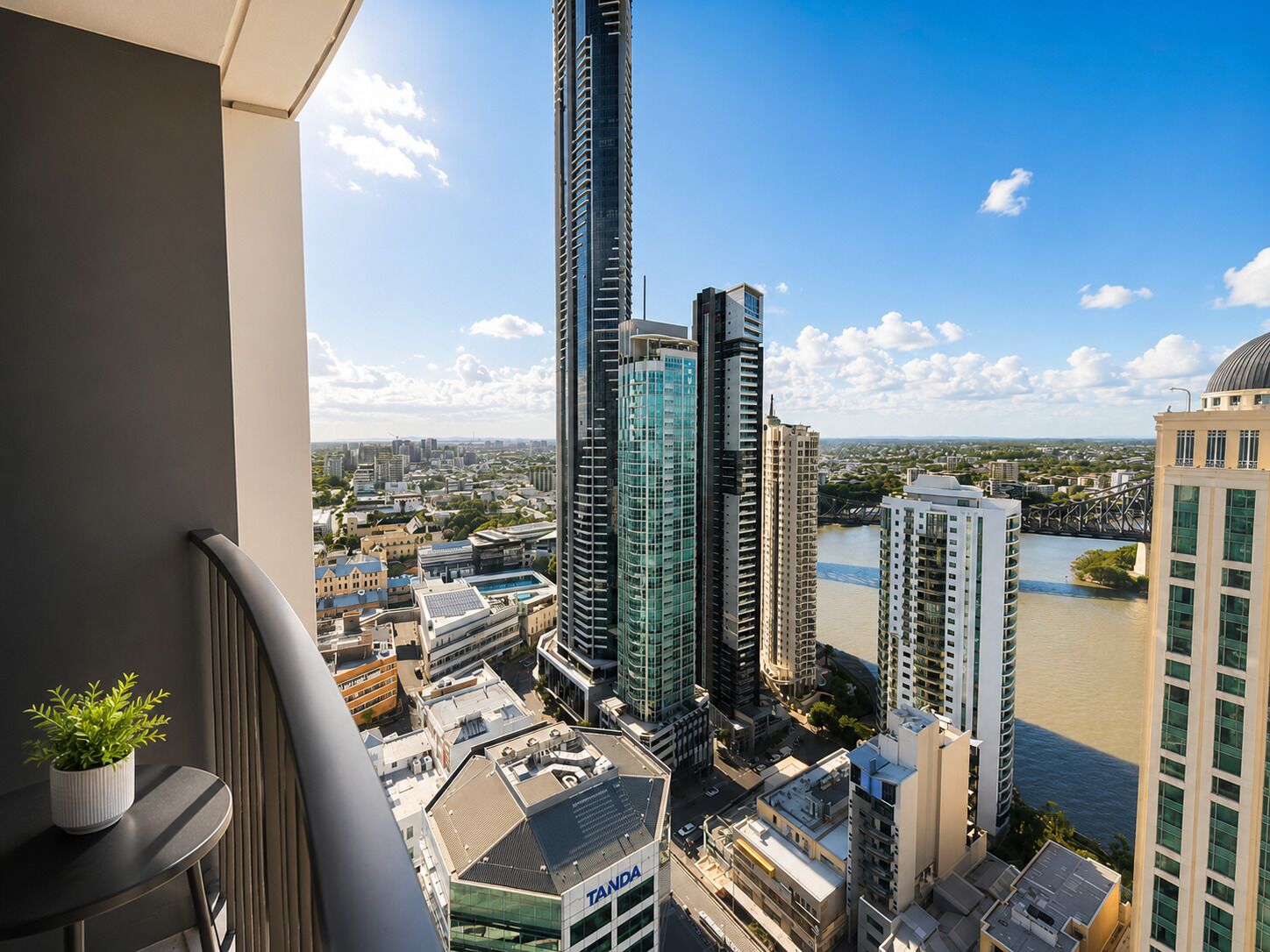 A high-rise building with a view of a river and other buildings.
