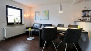 Ein moderner Essbereich mit einer schwarzen Ledersofa, einem runden Tisch und schwarzen Stühlen.