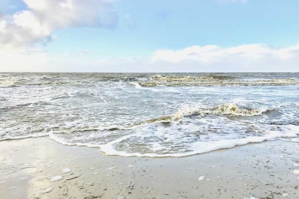 Une plage où les vagues se brisent près du rivage.