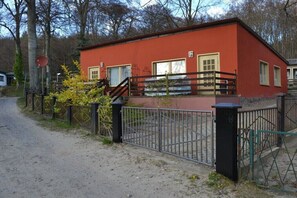 Ein rotes Gebäude mit geschlossenem Eingangsbereich, einer kleinen Veranda und einer sichtbaren Tür.