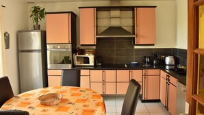 A compact kitchen with a refrigerator, microwave, stove, and a sink. - Normandy Gite With Bay Views (Courtils)
