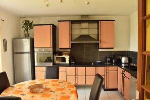 A compact kitchen with a refrigerator, microwave, stove, and a sink. - Normandy Gite With Bay Views (Courtils)