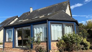A house with a sloped roof, large windows, and a brick exterior. - Normandy Gite With Bay Views (Courtils)