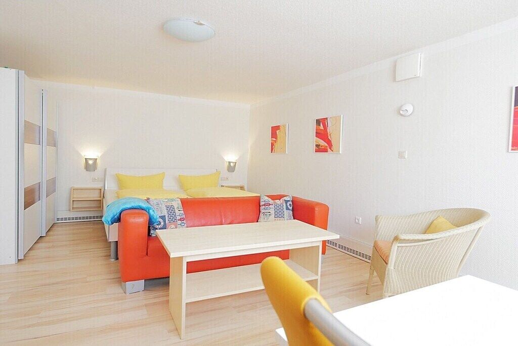 Une chambre à coucher moderne avec un lit, un canapé, une table et une chaise.