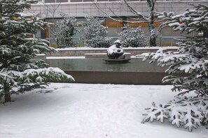 A snow-covered outdoor area with a fountain and snow-laden trees. - Villa Jansen 5 - OG/DG (Wenningstedt)