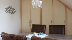 Un espace repas comprenant une table, des chaises et un lustre.