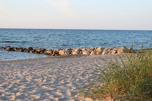 A sandy beach with a rocky breakwater and clear blue water. - Holiday apartment with 1 bedroom (Timmendorfer Strand - Niendorf)