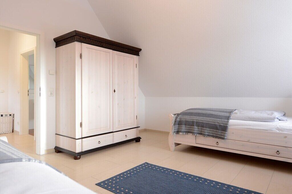 A bedroom with a bed, a wardrobe, and a rug.