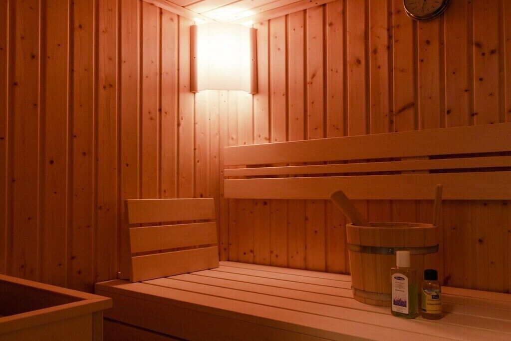 A wooden sauna with benches and a bucket.