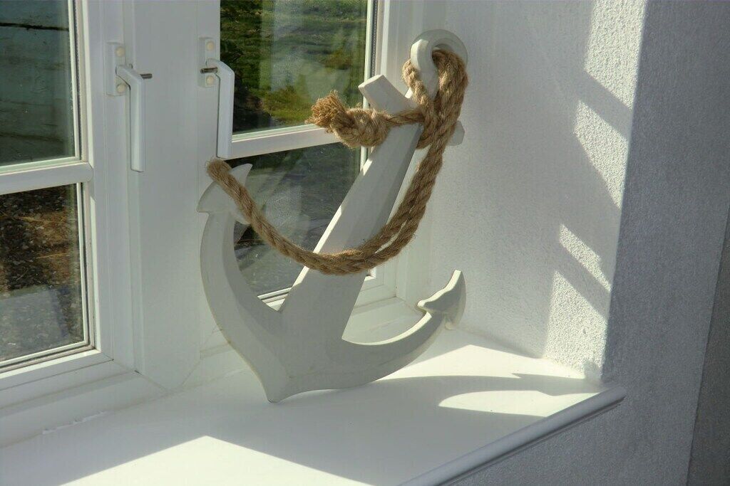 A white anchor decoration on a window sill.