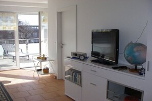 Ein Zimmer mit Fernseher, Globus und Schreibtisch mit Stuhl.